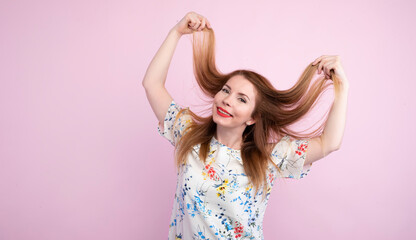 Cheerful young brownhead woman girl in casual dress posing isolated on pink wall background studio portrait. People lifestyle concept. Mock up copy space. Having fun, throwing up flying hair.