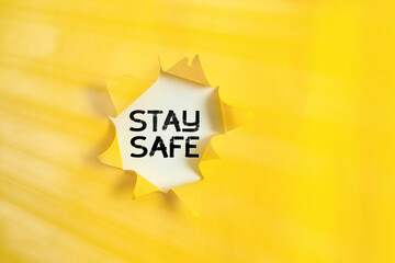 Handwriting text Stay Safe. Conceptual photo secure from threat of danger, harm or place to keep articles Rolled ripped torn cardboard placed above a wooden classic table backdrop