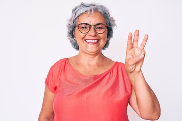 Senior hispanic grey- haired woman wearing casual clothes and glasses showing and pointing up with...