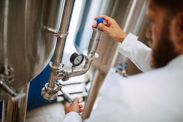 Professional caucasian technologist expert controlling industrial process in production plant. Industrial worker with protective uniform checking productivity in food factory.