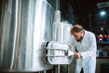 Professional caucasian technologist expert controlling industrial process in production plant. Industrial worker with protective uniform checking productivity in food factory.