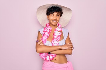 Young beautiful african american tourist woman wearing bikini and hawaiian lei flowers happy face...