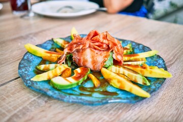 Delicious dish of salad with avocado, lettuce and salmon at restaurant.