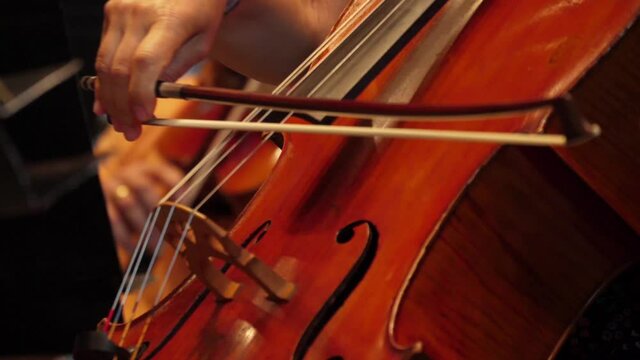 cellist playing cello in orchestra slow motion