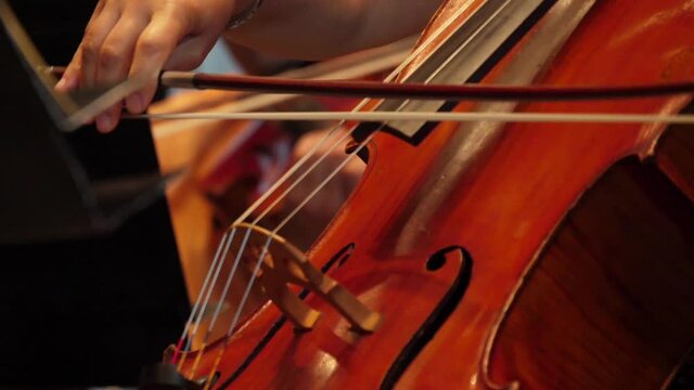 cellist playing cello in orchestra slow motion