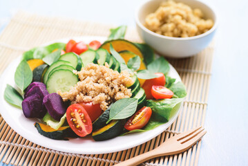 Salad vegetables with quinoa seeds on plate, Healthy vegan food	