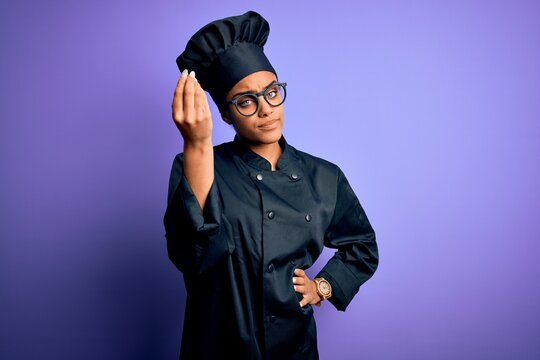Young african american chef girl wearing cooker uniform and hat over purple background Doing Italian gesture with hand and fingers confident expression - Powered by Adobe