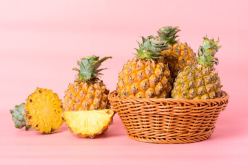 Fresh pineapple fruit in a basket on pastel pink background, Tropical fruit