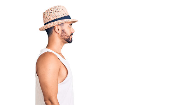 Young hispanic man wearing casual summer hat looking to side, relax profile pose with natural face with confident smile.