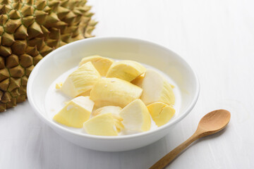 Thai dessert, sliced durian fruit with coconut milk in a bowl on white table background