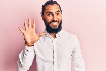 Young arab man wearing casual clothes showing and pointing up with fingers number five while smiling confident and happy.