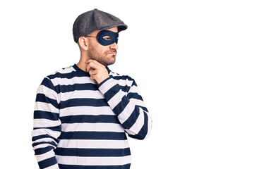 Young handsome man wearing burglar mask touching painful neck, sore throat for flu, clod and infection