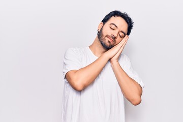 Young hispanic man wearing casual clothes sleeping tired dreaming and posing with hands together while smiling with closed eyes.