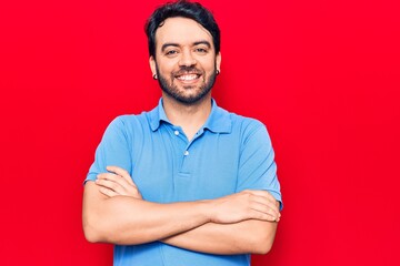 Young hispanic man wearing casual clothes happy face smiling with crossed arms looking at the camera. positive person.