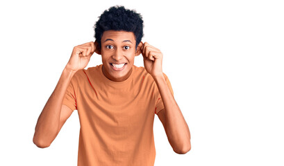 Young african american man wearing casual clothes smiling pulling ears with fingers, funny gesture....