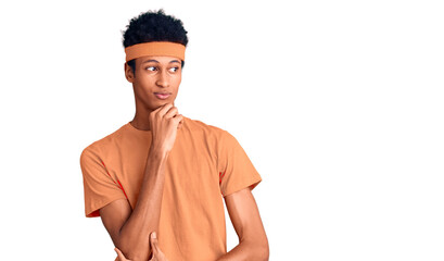 Young african american man wearing sportswear serious face thinking about question with hand on...