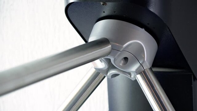 Woman passing the turnstile entering a gym wearing grey yoga pants on close up.