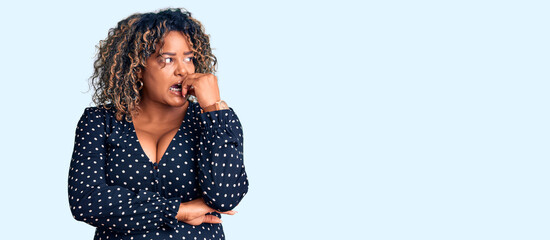 Young african american plus size woman wearing casual clothes looking stressed and nervous with hands on mouth biting nails. anxiety problem.