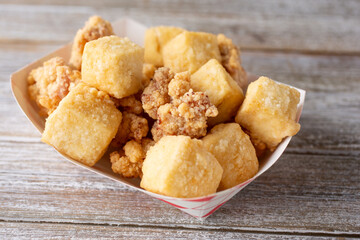 A view of a plate of deep fried tofu and popcorn chicken.