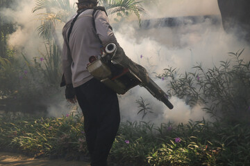 Handheld mosquitos fogger. Man fogging to eliminate mosquitos from the yard. Mosquito repellent...