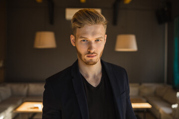 Obraz premium successful beautiful young man blond is located in a modern loft room, hookah.