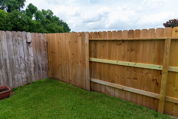 Wooden privacy fence, new and old in the same yard