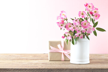 Pink rose flowers on vase on wooden table