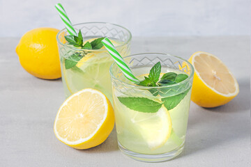 Lemon lemonade with herb on grey background.