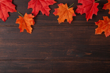 Naklejka na ściany i meble Autumn maple leaves on brown wooden table