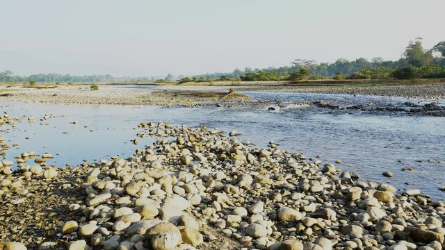 Murti riverbed in the morning, riverbed in foreground with flowing water and stones. Scenic beauty of Dooars landscape, West Bengal, India.