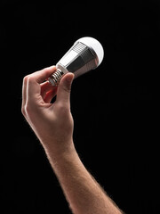 A hand holding an energy efficient light bulb.