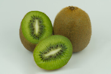 The fruits of the kiwi fruit are full and split in half on a white background.