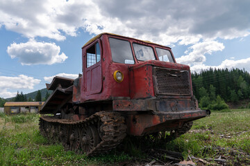 an old logging truck, rusty and abandoned in a field against the backdrop of a beautiful forest, as a symbol of the collapse of industry in Russia and Siberia. mismanagement