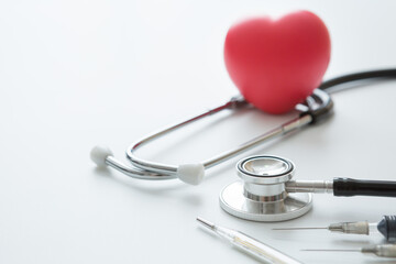 Selective focus of Heart shaped squeeze ball for hand muscle exercise stethoscope , Syringes and thermometer  on a white background and copy space