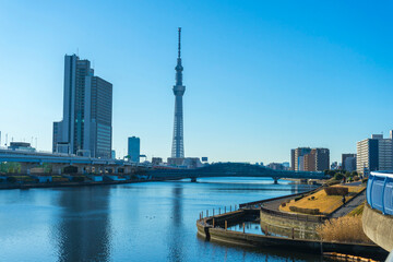 Fototapeta na wymiar Tokyo Skytree with blue sky background and Sumida river as foreground in Tokyo, Japan 