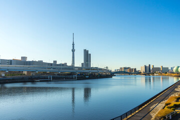 Naklejka na ściany i meble Tokyo Skytree with blue sky background and Sumida river as foreground in Tokyo, Japan 