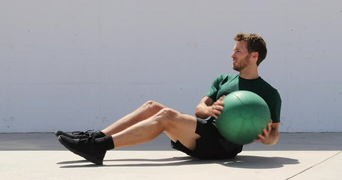 Medicine ball exercise - man doing russian twist in abs workout.
