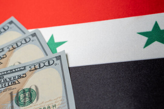 Syria national flag and the dollar bills. Business and finance concept, soft focus