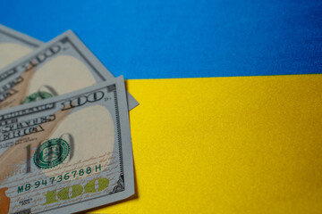 Ukraine national flag and the dollar bills. Business and finance concept, soft focus