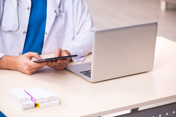 Fototapeta premium Young male doctor in telemedicine concept