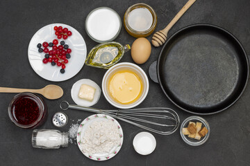 Obraz na płótnie Canvas Frying pan with cereal pancakes. Flour, berry yogurt, butter, honey jam.