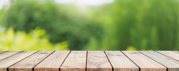 Empty wood table top and blurred green tree and vegetable in agricultural farms. background - can...