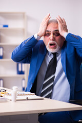Old face injured employee sitting in the office