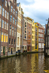 Fototapeta na wymiar View of Colorful houses and Boats on Amsterdam Canal in Amsterdam, Netherlands 