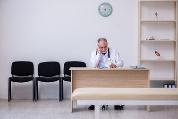Old male doctor working in the clinic