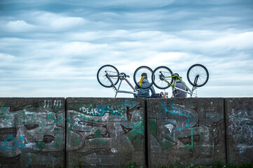 Fototapeta na wymiar two cyclists resting with their bicycles on a breakwater