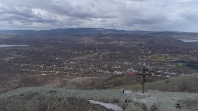 Orthodox cross on Mount Karabash and city view. the camera moves towards the city. Russia, Chelyabinsk region