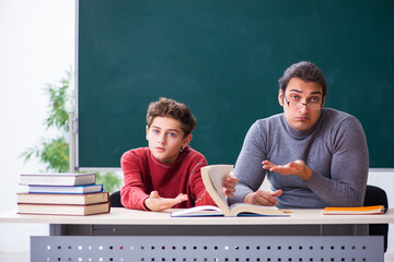 Young male teacher and schoolboy in the classroom