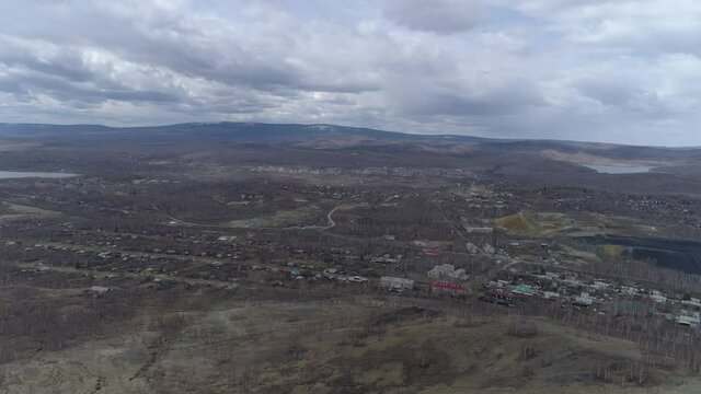 Aerial view of Orthodox cross on Mount Karabash and city. The camera flies from the city through the cross. Russia, Chelyabinsk region