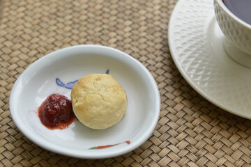 Homemade Scones with Strawberry jam on Bamboo table background.